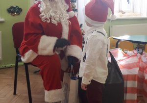 Św. Mikołaj wita się z chłopcem.